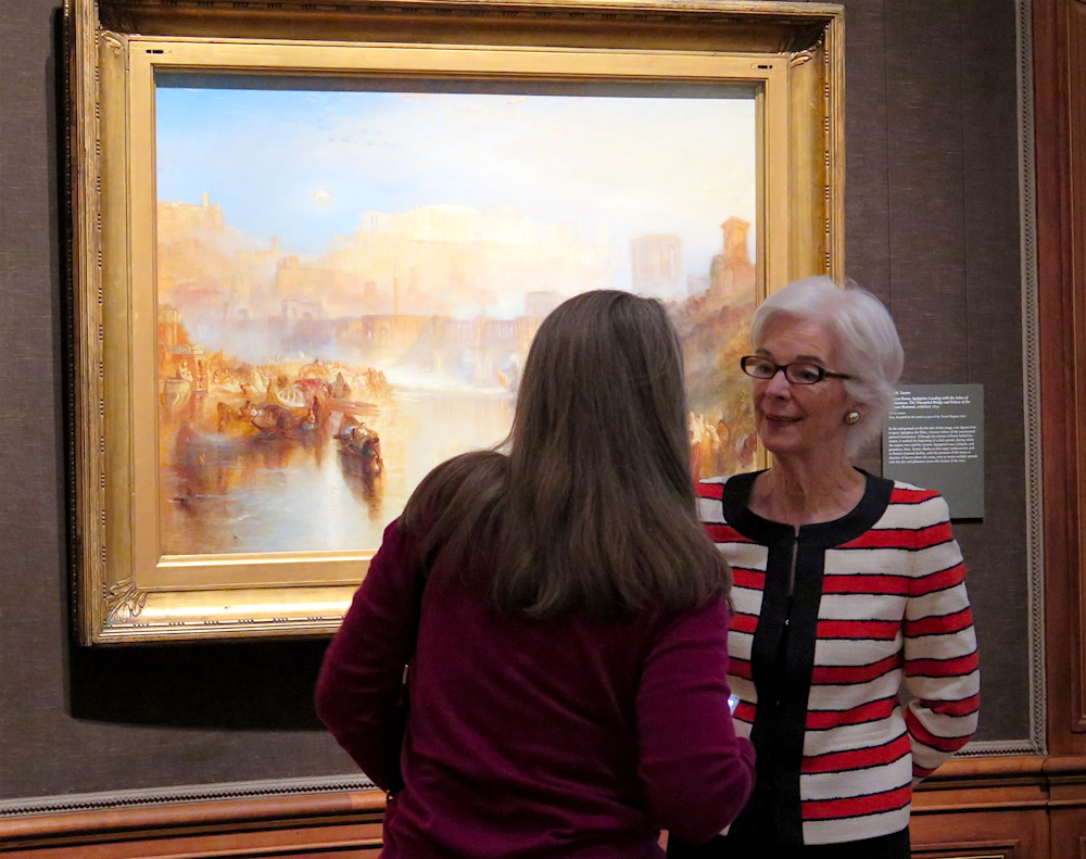 Susan Grace Galas, Senior Curator, The Frick Collection, in front of J.M.W. Turner's Ancient Rome; Agrippina Landing with the Ashes of Germanicus. The Triumphal Bridge and Palace of the Caesars Restored, exhibited 1839 Oil on canvas (photo credit ©MRNY)